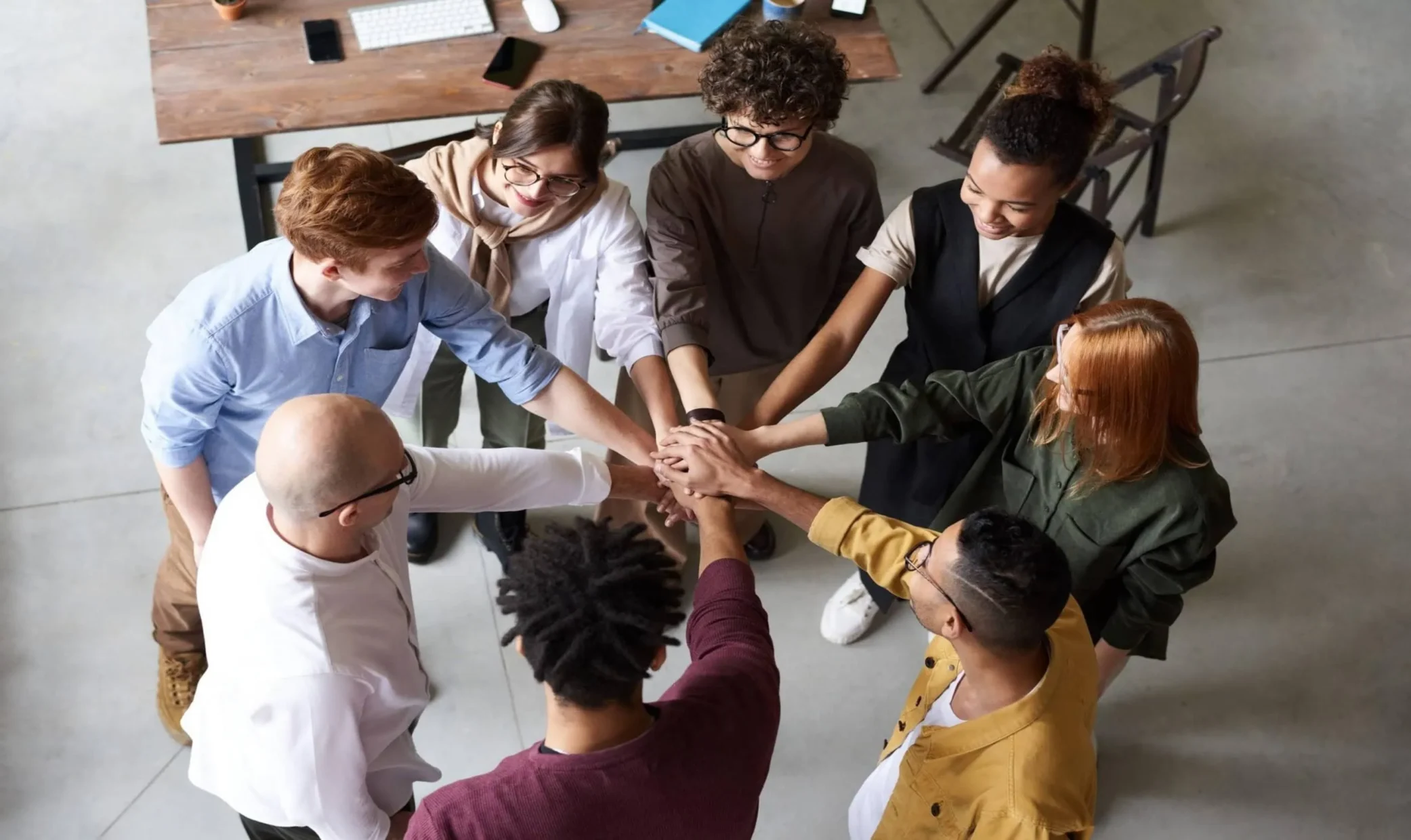 aerial shot of a group touching hands in a circle