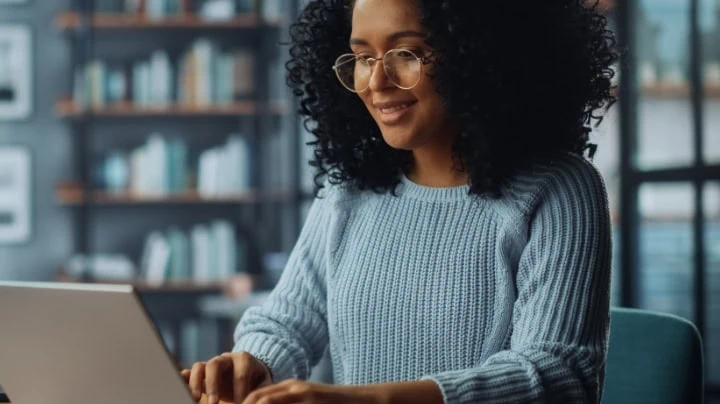 Woman smiling typing on computer