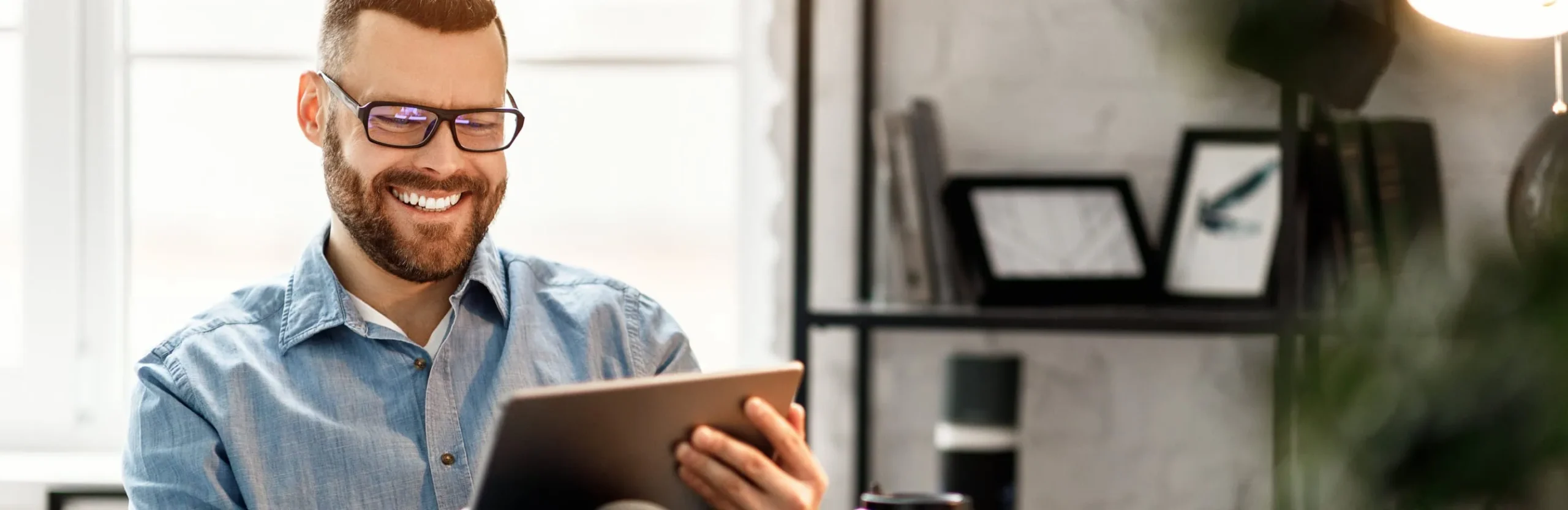 Man Smiling Viewing Tablet Device