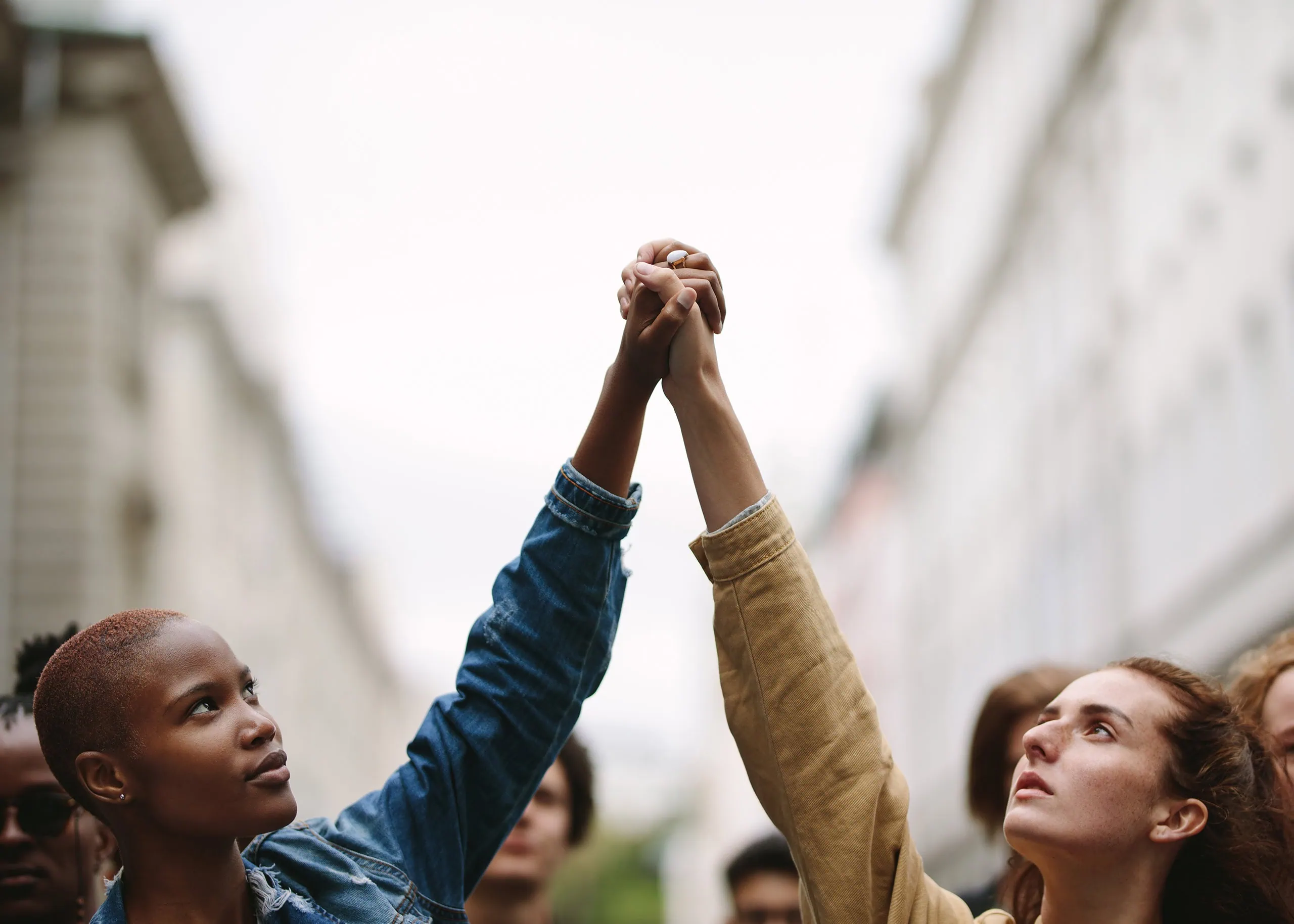 Two women holding holding hands raised above head